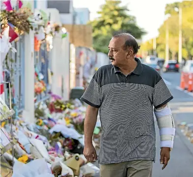  ?? JOSEPH JOHNSON/STUFF ?? Mohammad Shammin Siddiqui finds comfort in looking at the flowers and cards outside the AlNoor mosque on Deans Ave.
And left: An Islam Against Extremism group member, right, worships on a day Mohammad Shammin Siddiqui visits the Al Noor mosque.