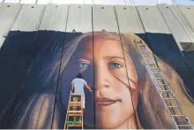  ?? AP ?? An artist paints a giant mural of Ahed Tamimi on the Israeli wall in the occupied West Bank city of Bethlehem.