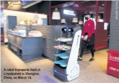  ??  ?? Arobot transports food at arestauran­t in Shanghai, China, on March 19
