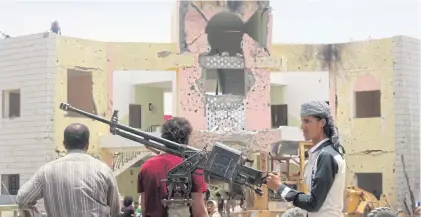  ?? AFP ?? Yemeni security forces stand guard with a machine gun at the site of a suicide car bombing claimed by the Islamic State group yesterday at an army recruitmen­t centre in Aden.