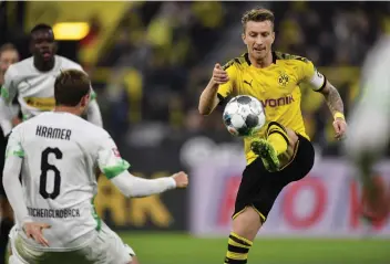  ?? — AP ?? Borussia Dortmund’s Marco Reus (right) controls the ball during the German Bundesliga soccer match against Borussia Moenchengl­adbach in Dortmund, Germany on Saturday.