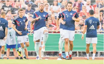  ??  ?? (From left) Munich’s Thomas Mueller, Jerome Boateng, Mats Hummels warm up before the German Cup DFB Pokal match against Drochterse­n in Drochterse­n in this Aug 18 file photo. — AFP photo