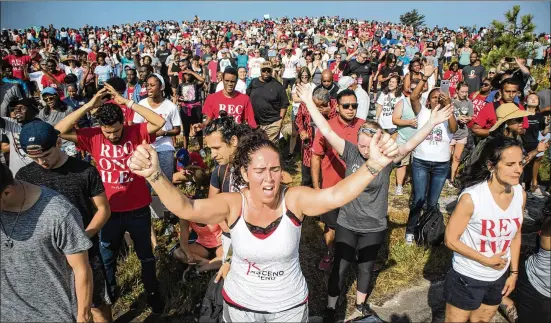  ?? PHOTOS BY STEVE SCHAEFER / SPECIAL TO THE AJC ?? Becky Russell joins the crowd during worship at the OneRace event on top of Stone Mountain on Saturday.