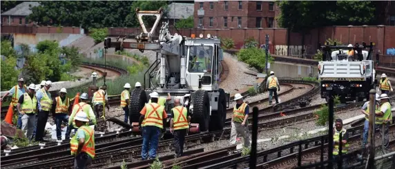  ?? FAITH NINIVAGGI / HERALD STAFF FILE ?? OPEN UP THE WALLET: MBTA workers begin to remove the damaged tracks at the JFK/UMass MBTA station where a Red Line train derailed on June 12. Red Line riders, right, wait for a train at Park Street station on July 10.
