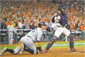  ??  ?? Astros catcher Robinson Chirinos, right, celebrates after tagging out the Yankees’ DJ LeMahieu, who tried to score on a single by Brett Gardner during the sixth inning.