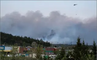  ?? CANADIAN PRESS PHOTO ?? A helicopter carrying water flies over smoke from a wildfire in a community outside of Halifax last weekend.