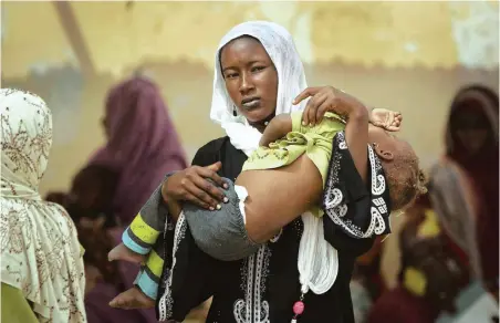  ?? PICTURE: AP ?? UNDER THREAT: A woman carries her child at a walk-in feeding centre in Mao, capital of the Kanem region of Chad. Unicef estimates that 127 000 children under five in Chad’s Sahel belt will require life-saving treatment for malnutriti­on this year.