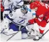  ??  ?? PAUL SANCYA/Associated Press Tampa Bay goalie Ben Bishop, left, stops Detroit’s Tomas Jurco Sunday at Joe Louis.