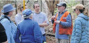  ?? JASON MALLOY ?? Ron Neville, second from right, a survey biologist with the Canadian Food Inspection Agency, speaks with participan­ts at a hemlock woolly adelgid workshop April 15 in Kentville.