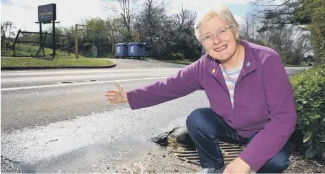  ?? ?? Christine Lindsay, who is concerned about a continuous flood in the road. Picture by Steve Robards