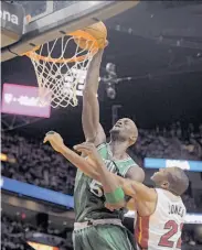  ?? Michael Laughlin / MCT / Sun Sentinel ?? Kevin Garnett, dunking over Miami’s James Jones, had 26 points and 11 rebounds to lead Boston.