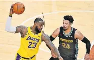  ??  ?? Los Angeles Lakers forward LeBron James (23) looks to pass the ball while Memphis Grizzlies guard Dillon Brooks (24) defends during Tuesday night's game in Memphis, Tenn. [AP PHOTO/BRANDON DILL]