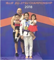  ??  ?? 2018 Asian Open IBJJF Jiu-Jitsu Championsh­ip (in Tokyo) Gold Open Weight Division Blue Belt Champion Alexandra Lee, 25, shown here carrrying her daughter Kyra, 2, and with husband Alvin, and son Xander, 4.