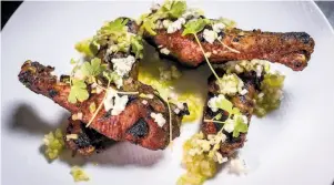  ??  ?? The smoked duck wings are a clever take on the familiar Buffalo chicken wings, covered with a tiny celery dice, blue cheese and wisps of tender sprouts.