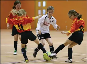  ??  ?? Sophie Coughlan and Kate Dowling from Moycarkey, Tipperary, try to clear the ball as Clodagh Heron from Fanad, Donegal, closes in during the Girls Under 10 Indoor Soccer Final