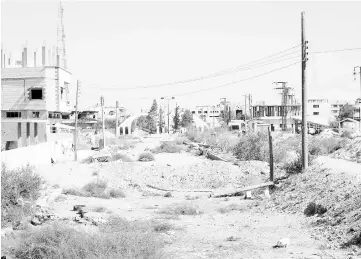  ??  ?? A general view shows a heavily damaged road in the recently retaken desert town of Al-Qaryatain. — AFP photo