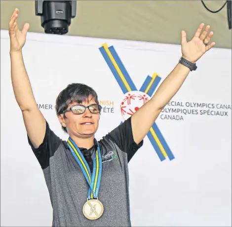  ?? COREY LEBLANC/SALTWIRE NETWORK ?? Teri Cudmore of Charlottet­own raises her arms in the air after being presented with the silver medal for the 100 metres at the Special Olympics Canada 2018 Summer Games Saturday in Antigonish, N.S.