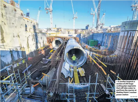  ?? Ben Birchall ?? A worker inspects a section of 293 huge cooling pipe segments that will take water to and from the reactor at Hinkley Point C nuclear power station