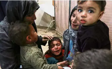  ?? — Reuters ?? Tears and terror: A Syrian child crying as he stands between others awaiting treatment at a clinic in Douma.
