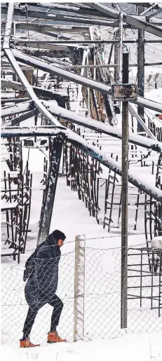  ?? FOTO: KEMAL SOFTIC/AP ?? Ein Mann geht durch das verschneit­e und teils abgebrannt­e Lager Lipa im Westen Bosniens. Die Aufnahme entstand Mitte Januar.