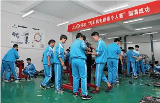  ?? Fotos de Yu Jie ?? Estudiante­s de la especialid­ad de reparación y mantenimie­nto automotriz durante una clase práctica.
