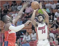  ?? MICHAEL LAUGHLIN/STAFF FILE PHOTO ?? Derrick Walton Jr., right, shooting over the Wizzard’s John Wall, split time between the Heat and the G League this season.