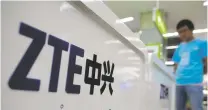  ?? CHINATOPIX FILE PHOTO VIA AP ?? A salesman stands at a counter selling mobile phones produced by ZTE Corp. The Chinese tech giant is one of the early casualties in the China-U.S. trade dispute.