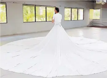  ?? ORLANDO BALLET ?? Orlando Ballet artistic director Robert Hill tries on the distinctiv­e outfit to perform “The Calling,” a solo piece by choreograp­her Jessica Lang.