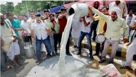  ?? — PTI ?? Members of All-India Nationalis­t Farmers and Labour Organisati­on spill milk on the road during a protest over farmers’ issues in Patna on Friday.