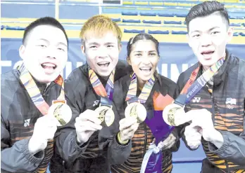  ?? - Bernama photo ?? National shuttlers (from left) Aaron Chia, Soh Wooi Yik, Kosina Selvaduraj and Lee Zii Jia with their gold medal haul in the SEA Games at the Muntinlup Sports Complex in Manila.