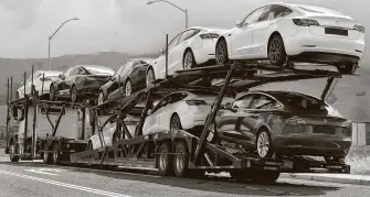  ?? Ben Margot / Associated Press ?? A truck loaded with cars leaves the Tesla plant in Fremont, Calif. CEO Elon Musk, saying the virus risk is insignific­ant, has reopened a Tesla factory despite Alameda County orders to cease.