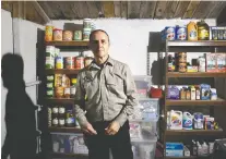  ??  ?? Drew Miller stands inside a well-stocked fortified bunker that is still under constructi­on.