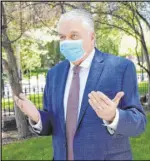  ??  ?? A masked Gov. Steve Sisolak speaks to reporters Wednesday outside the Capitol, discussing spending cuts and other measures.