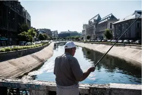  ?? Picture: Bloomberg ?? DOLCE VITA. An man fishes from a bridge in a city river in central Bucharest, Romania. Property group Nepi is investing heavily in shopping centres in eastern Europe and it’s winning dividends for investors.