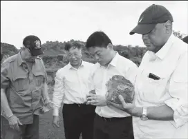  ?? (DPI photo) ?? Minister of Natural Resources Raphael Trotman (right) examines the manganese mineral with Steven Ma (second from right), Assistant General Manager of Bosai’s Overseas Department and Chinese Ambassador to Guyana Cui Jianchun (third from right.)