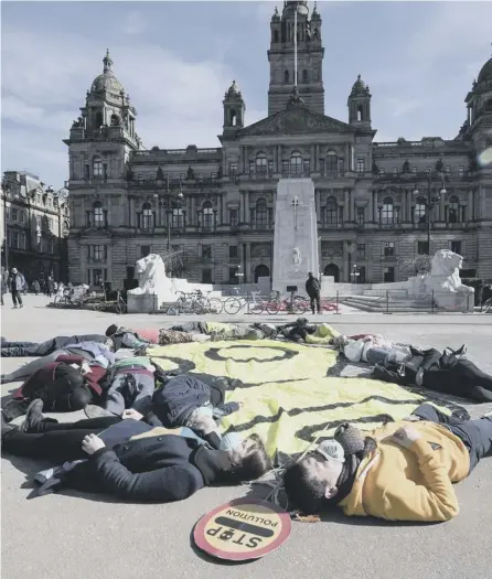  ?? PICTURE: JOHN DEVLIN ?? 0 Air pollution protesters wearing gas masks stage a “die-in” in Glasgow’s George Square