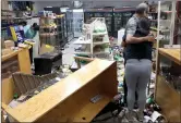  ??  ?? Chicago store owners clean up after a looting.