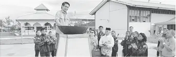  ??  ?? Dennis lights the torch to declare open SMK Lutong’s new sports field.