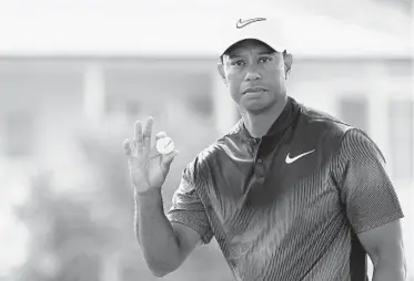  ?? MIKE EHRMANN/GETTY IMAGES ?? Tiger Woods reacts after making par on the fifth hole Saturday. He went 14 holes until making his first birdie.