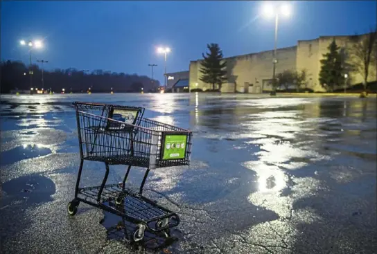  ?? Stephanie Strasburg/Post-Gazette ?? A shopping car sits in a puddled pothole Sunday outside Century III Mall in West Mifflin.