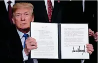  ??  ?? HERE WE GO AGAIN: President Trump holds his signed memo on IP tariffs on high-tech goods from China at the White House. — Reuters