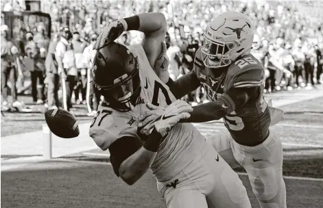  ?? Photos by Chuck Burton / Associated Press ?? Texas safety B.J. Foster breaks up a fourth-and-1 pass to denyWest Virginia tight end Mike O’Laughlin a fourth-quarter score.