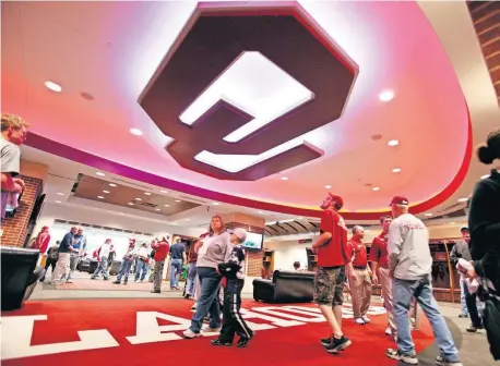  ?? [OKLAHOMAN ARCHIVES] ?? Season-ticket holders tour the OU football locker room in 2010. Between the time the Switzer Center originally opened in 1999 and that open house in 2010, the facility was renovated multiple times -- and has been overhauled multiple times since. The upgrade of facilities became a regular occurrence after the 2000 Sooners won the national title.