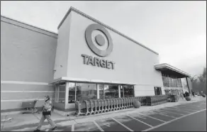  ??  ?? Target trouble: A passer-by walks near an entrance to a Target retail store in Watertown, Mass. Target says that personal informatio­n — including phone numbers and email and mailing addresses — was stolen from as many as 70 million customers in its...