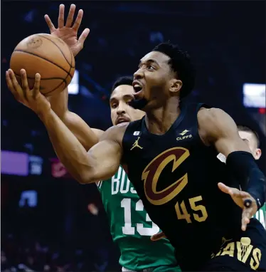  ?? RON SCHWANE — THE ASSOCIATED PRESS ?? Cleveland Cavaliers guard Donovan Mitchell (45) shoots against Boston Celtics guard Malcolm Brogdon during the first half of Monday night's game in Cleveland won by the Cavaliers 118-114. Mitchell scored 40 points and grabbed 11 rebounds.