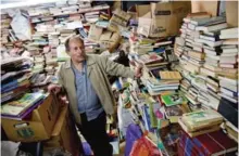  ??  ?? Jose Alberto Gutierrez checks books stacked in his library on the first floor of his house.