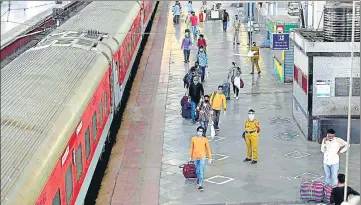  ?? PTI PHOTO ?? People maintain distance while walking along the platform to board a special train bound for New Delhi at the Mumbai Central Railway Station on Tuesday.