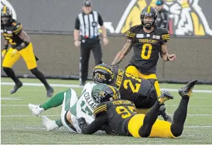  ?? PETER POWER THE CANADIAN PRESS FILE PHOTO ?? Saskatchew­an Roughrider­s quarterbac­k Zach Collar is hit late by Tiger-Cats’ Simoni Lawrence after Collaros was downed by Julian Howsare in Hamilton on June 13, 2019.