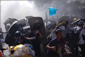  ?? (AP) ?? Protesters scatter Monday after riot police fired tear gas during a demonstrat­ion in Rangoon, Burma.