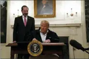  ?? EVAN VUCCI - THE ASSOCIATED PRESS ?? President Donald Trump signs an $8.3 billion bill to fight the coronaviru­s outbreak in the U.S., Friday, March 6, at the White House in Washington, as Department of Health and Human Services Secretary Alex Azar, looks on.